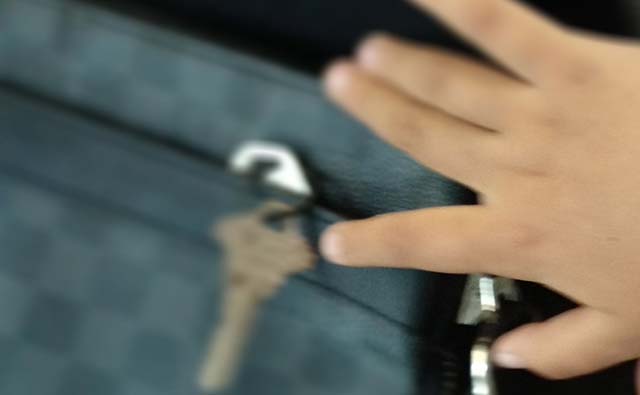 Tochter entfernt Schlüssel aus der Handtasche Kind nimmt Schlüssel aus der Tasche